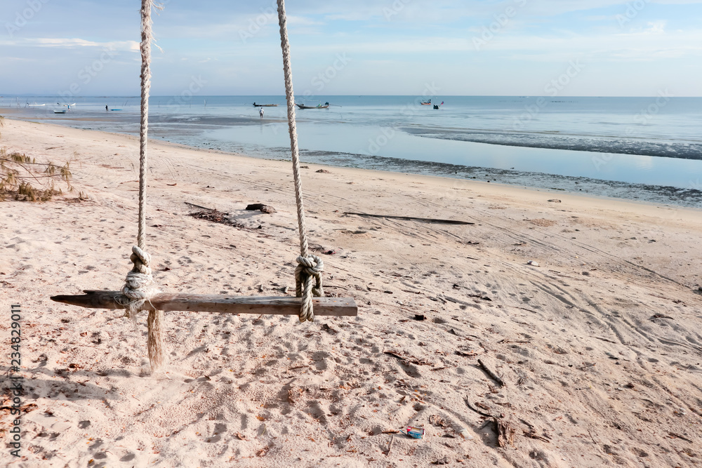 Fototapeta premium Wooden swing hanging on the beach.