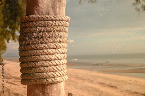 Принти на полотні Wooden post with mooring ropes on the beach.