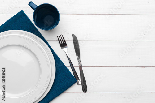 Empty plate and towel over wooden table background.