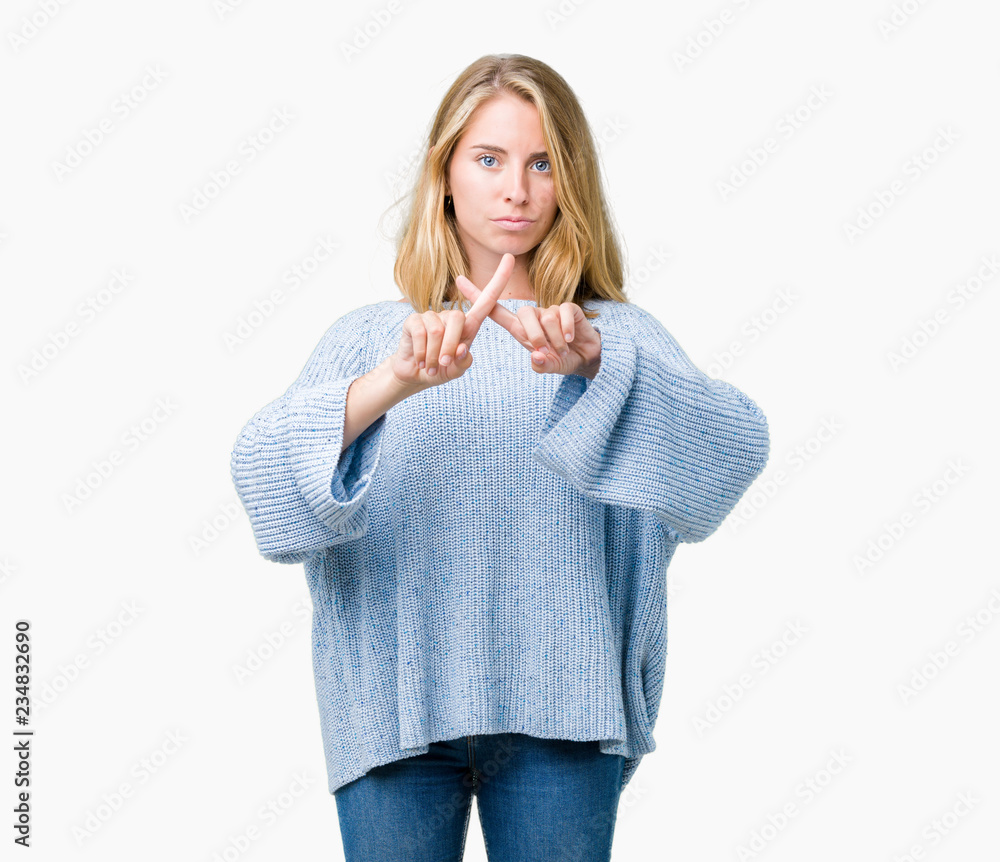 Beautiful young woman wearing blue sweater over isolated background Rejection expression crossing fingers doing negative sign Beautiful young woman wearing blue sweater over isolated background Rejection expression crossing fingers doing negative sign