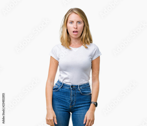 Beautiful young woman wearing casual white t-shirt over isolated background In shock face, looking skeptical and sarcastic, surprised with open mouth © Krakenimages.com