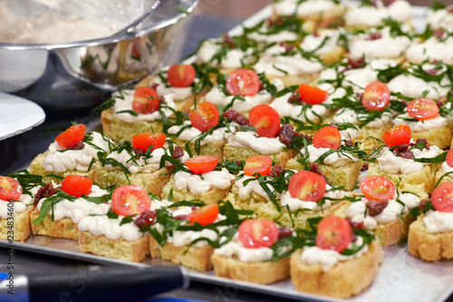A closeup of a side dish of canapes with tomatoes and cheese
