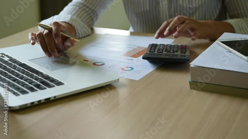 Close-up of business woman accountant making calculations financial data sheet with calculator, Business and financial concept