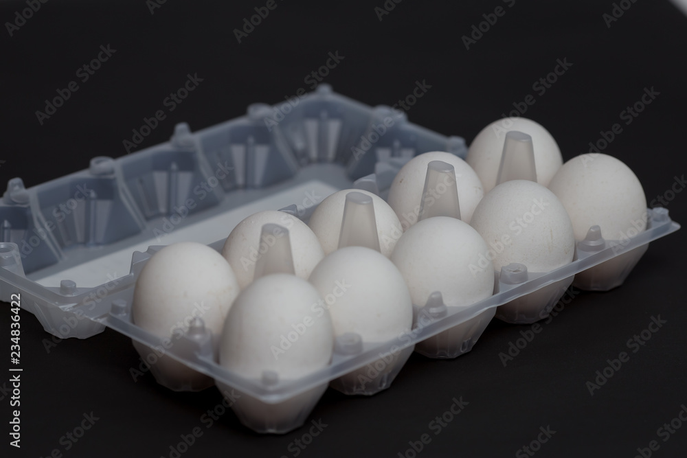 White chicken eggs on a dark background White chicken eggs on a dark background