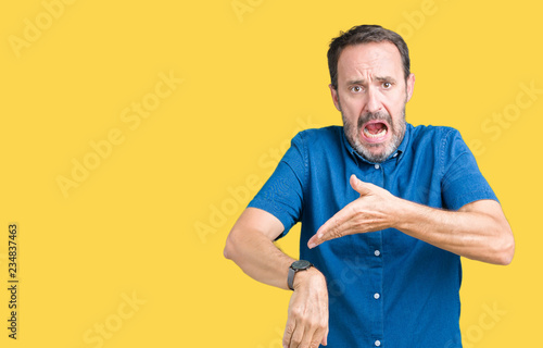 Handsome middle age elegant senior man over isolated background In hurry pointing to watch time, impatience, upset and angry for deadline delay photo