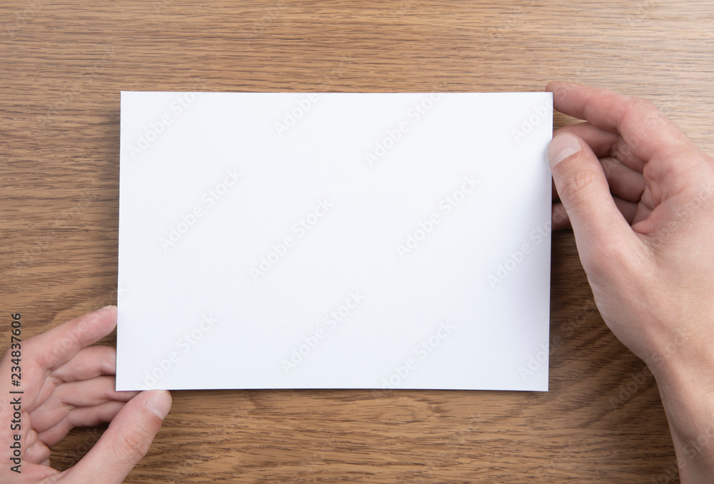 Obraz premium Mens hands holding empty white letterhead