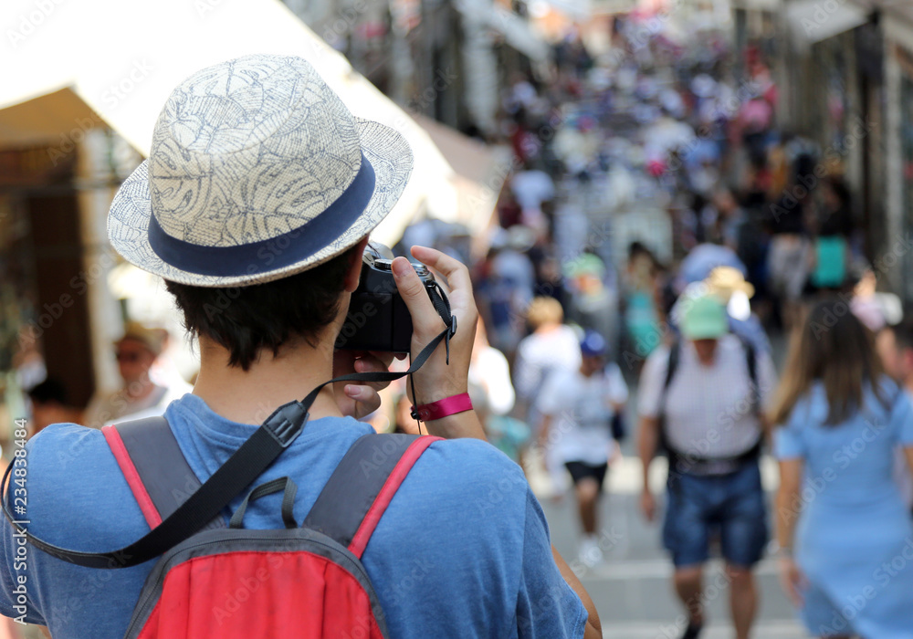 young boy with a straw hat photographs tourists young boy with a straw hat photographs tourists