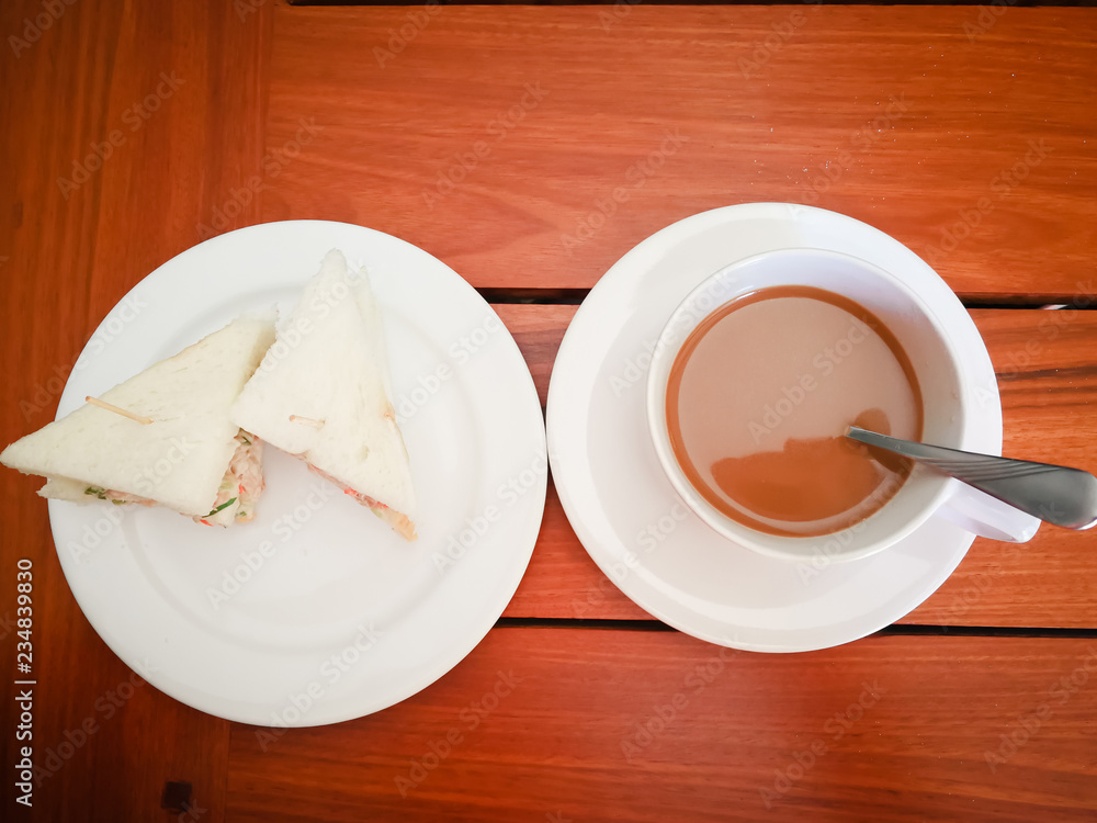 coffe and mini sandwich in white dish on wooden table coffe and mini sandwich in white dish on wooden table