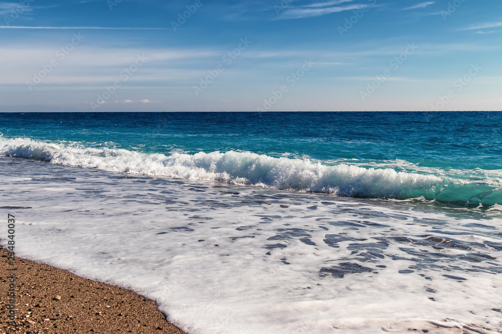 waves of the Mediterranean sea roll on the pebble beach