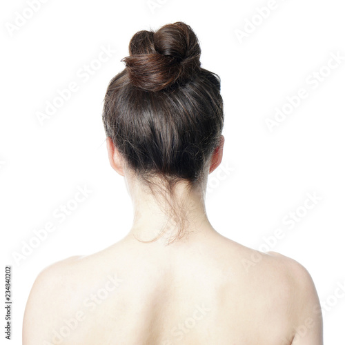 head and shoulder back view of young woman with messy bun - undone hair style fashion trend