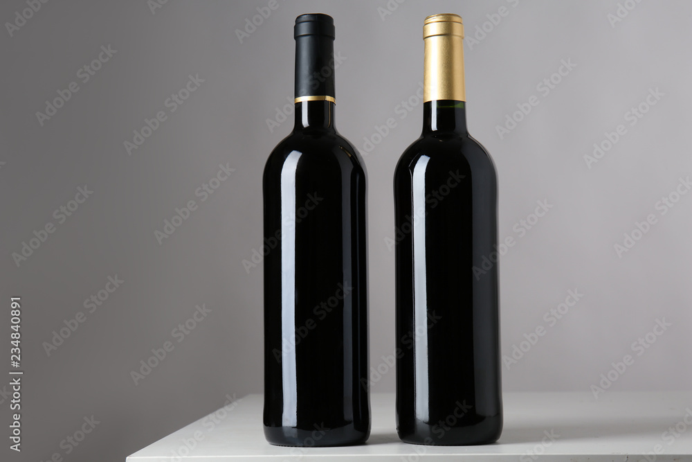 Bottles of red wine on grey background Bottles of red wine on grey background