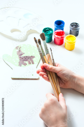 Paint brushes in the hands of a girl.