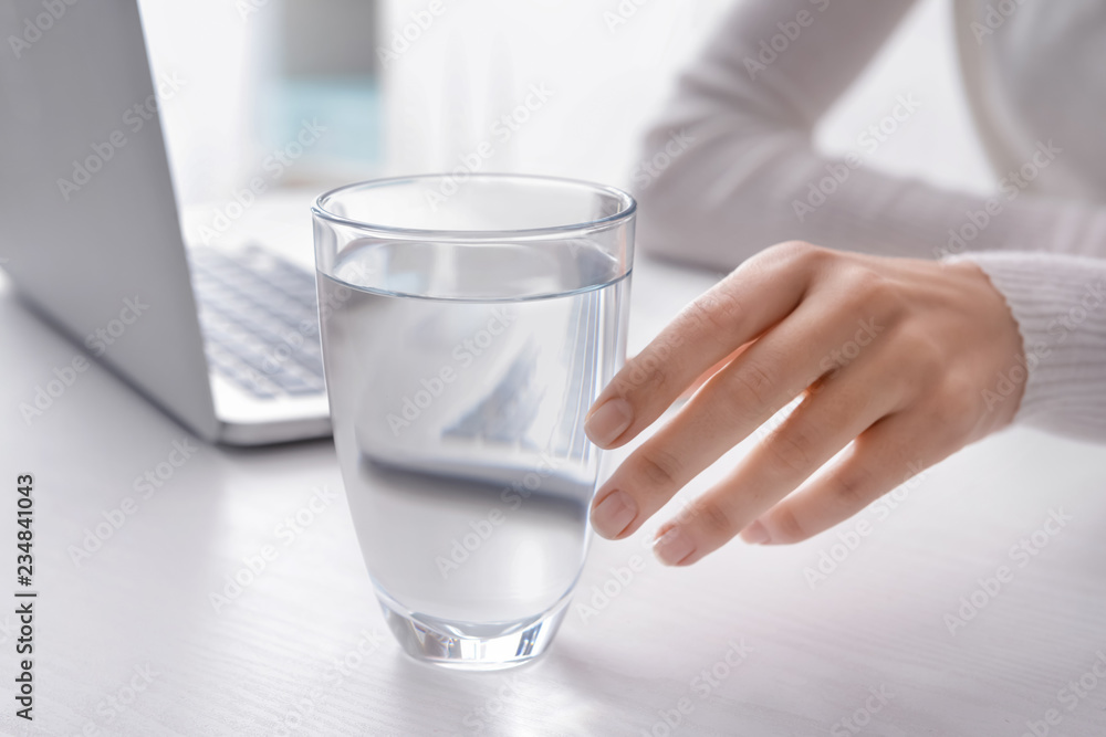 Woman taking glass of fresh water from white table Woman taking glass of fresh water from white table