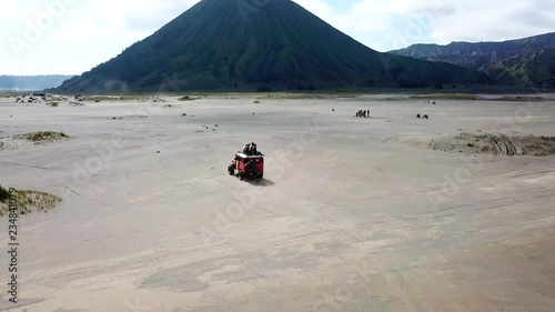 4K Tracking by drone on driving experience to Mt.Bromo, Pasuruan, East Java, Indonesia. Adventure driving Off-road Jeep 4WD into Beautiful active Volcano with smoke Mount Bromo.