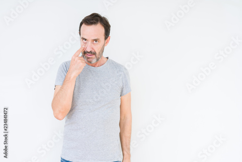 Handsome senior man over isolated background Pointing to the eye watching you gesture, suspicious expression