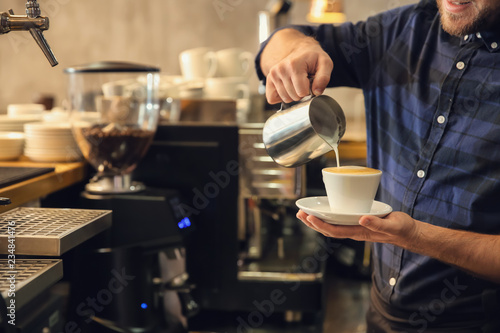 Barista preparing fresh aromatic coffee in cafe