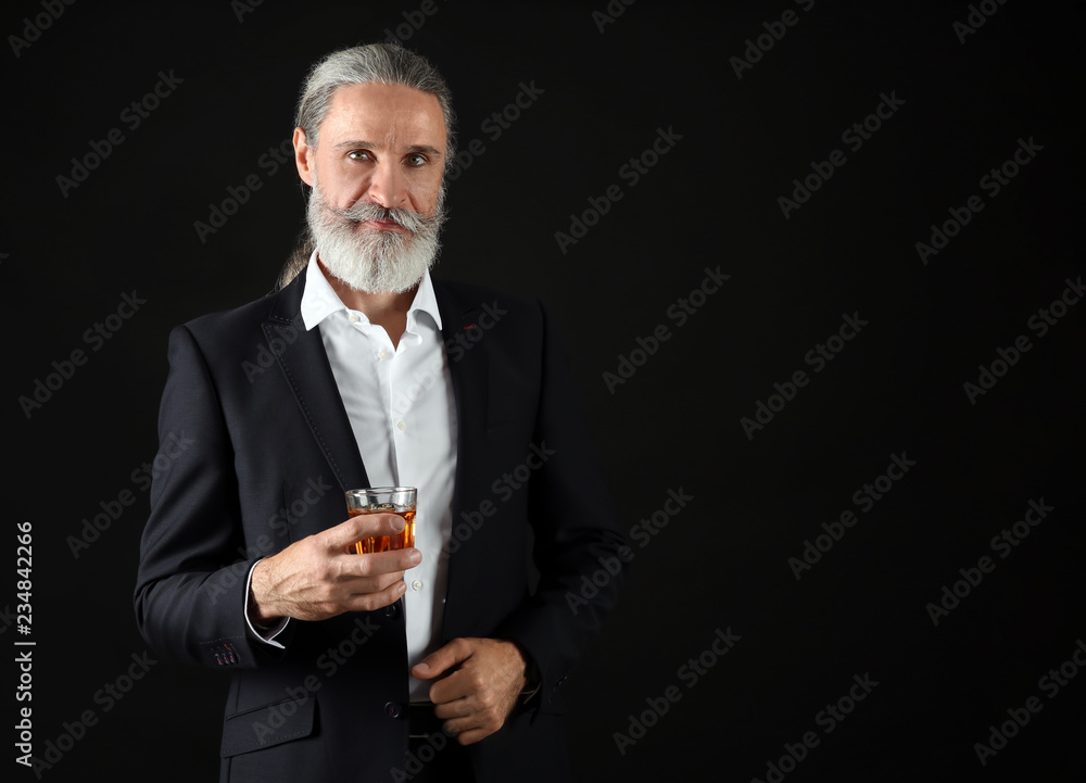 Elderly businessman with glass of whiskey on dark background Elderly businessman with glass of whiskey on dark background