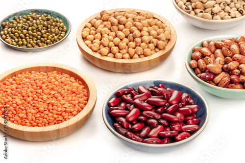 A photo of various types of legumes on a white background. Different beans, lentils, chickpeas, soybeans