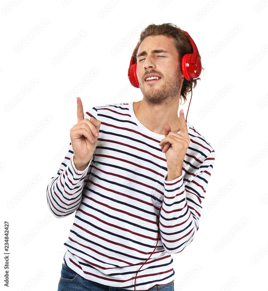 Naklejka premium Young man listening to music on white background
