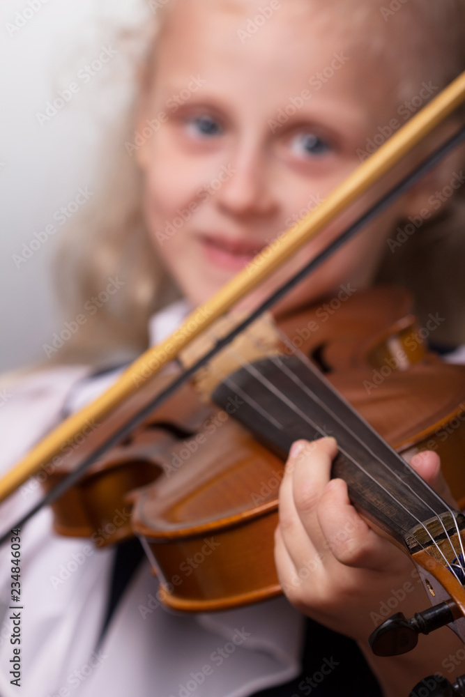 Smiling little girl in elegant clothes playing the violin Smiling little girl in elegant clothes playing the violin
