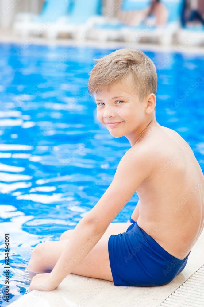 Portrait of a happy boy by the pool