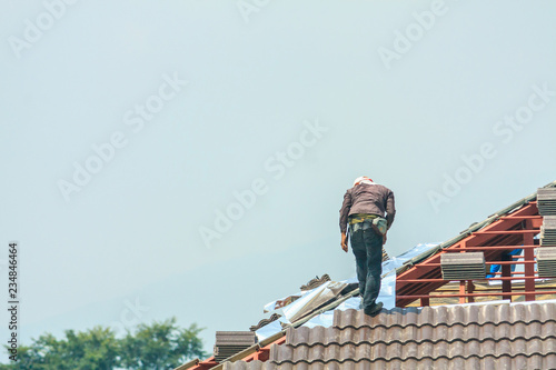 Wallpaper Mural Construction roofer installing roof tiles at house building site Torontodigital.ca