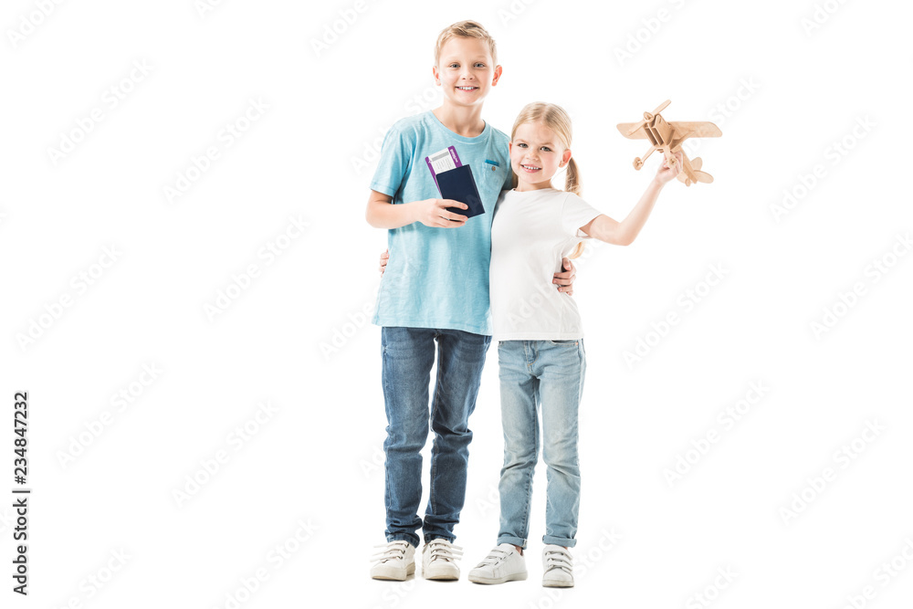 Sister and brother standing with passport and plane model isolated on white Sister and brother standing with passport and plane model isolated on white