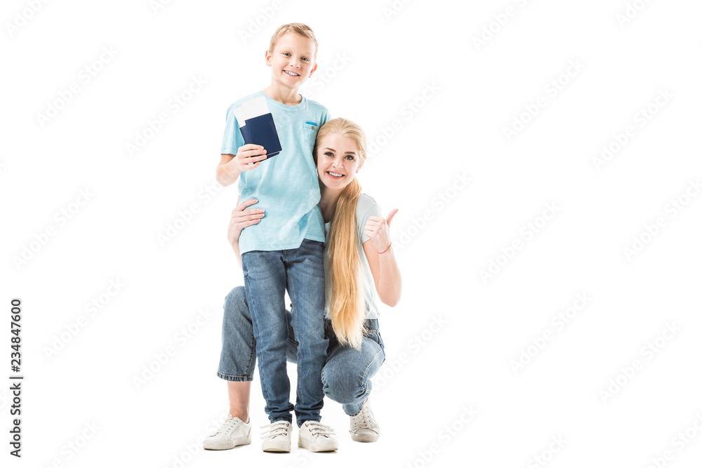 Mother showing thumbs up and son smiling and holding passport isolated on white Mother showing thumbs up and son smiling and holding passport isolated on white