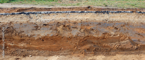 Cross-section of the pavement with layers of clay sand and asphalt. Panoramic collage from several outdoor photos