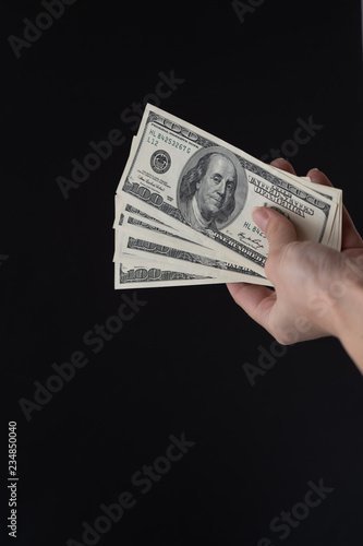 Hand holding dollars. Vertical. Space for text