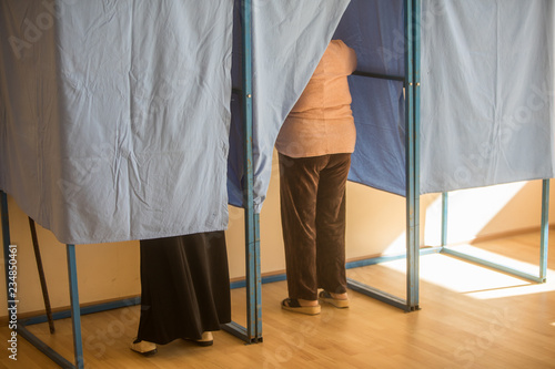 Fotografi Persons voting in booths at a polling station