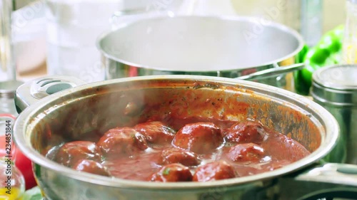 Preparing meatballs in tomato sauce with spaghetti pasta photo