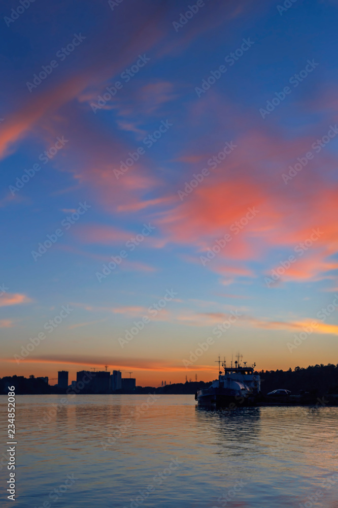 beautiful sunset on the river Neva with the silhouettes of the ship and the city