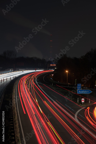 Autobahn bei Nacht mit Leuchtstreifen und Baustelle