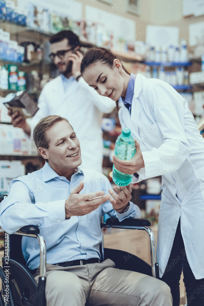 Obraz premium Man buys a mineral water in pharmacy