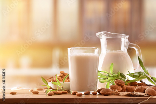 Fotografija Alternative milk of almonds on wood table in rustic kitchen