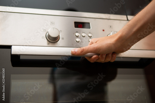 Image of oven and human hand