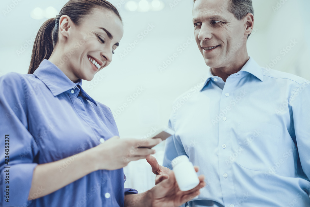 Obraz premium Man and woman buys a medicaments in pharmacy