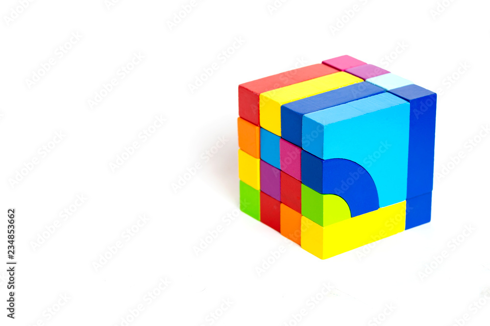 Colored wooden blocks, cubes, build on a light white background. A cube of colored wooden details Colored wooden blocks, cubes, build on a light white background. A cube of colored wooden details