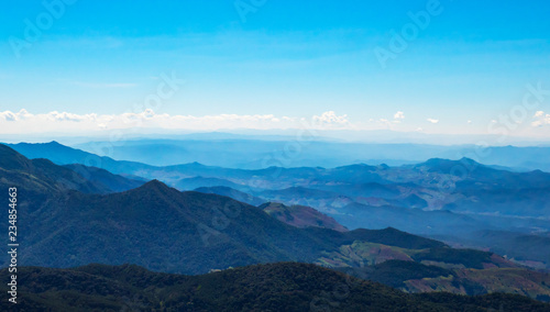 The mountains and forests with blue sky and white clouds at the peak of Inthanon national park (park name) in Chiang Mai province , Thailand in a sunny day. 