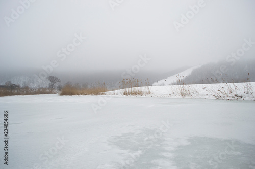 Beautiful winter meditative landscape of the frozen river.