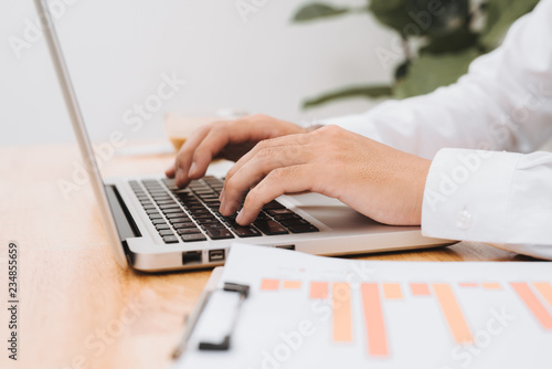 Business man using laptop computer. Male hand typing on laptop keyboard