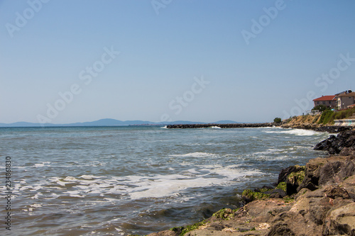 Landscape of the sea and sea coast with rocks and blue sky. Sea waves crashing on the rocks. Black sea. Ravda. Bulgaria. photo