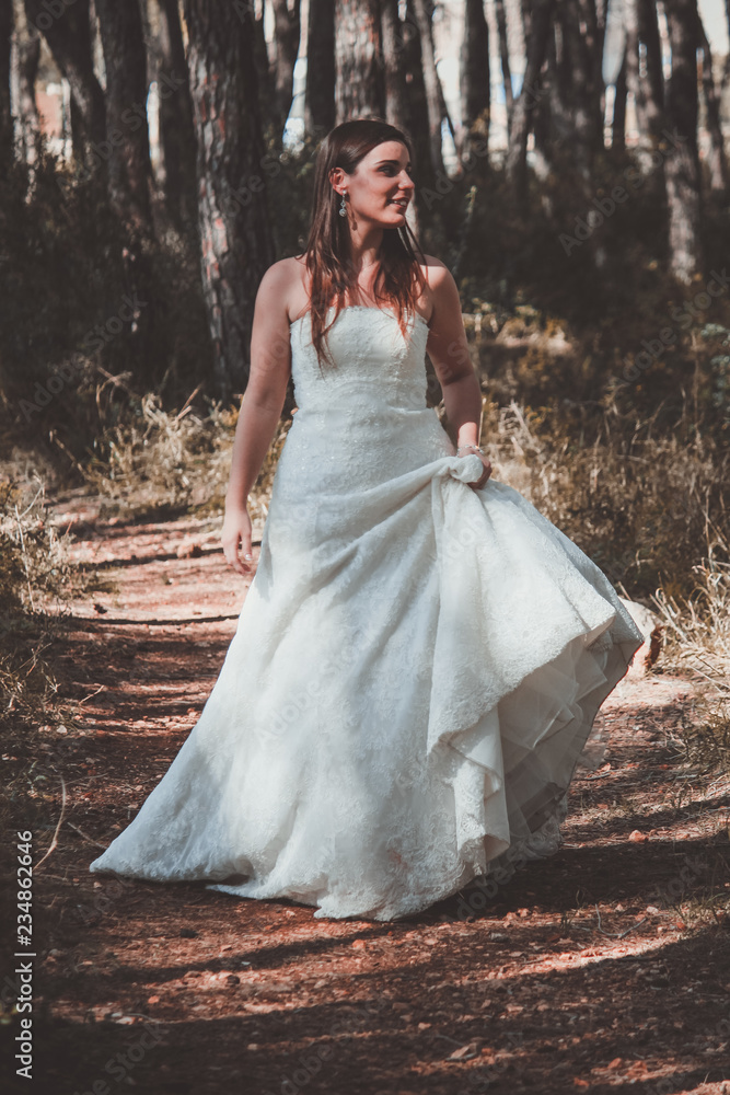 Stylish young bride posing in the woods