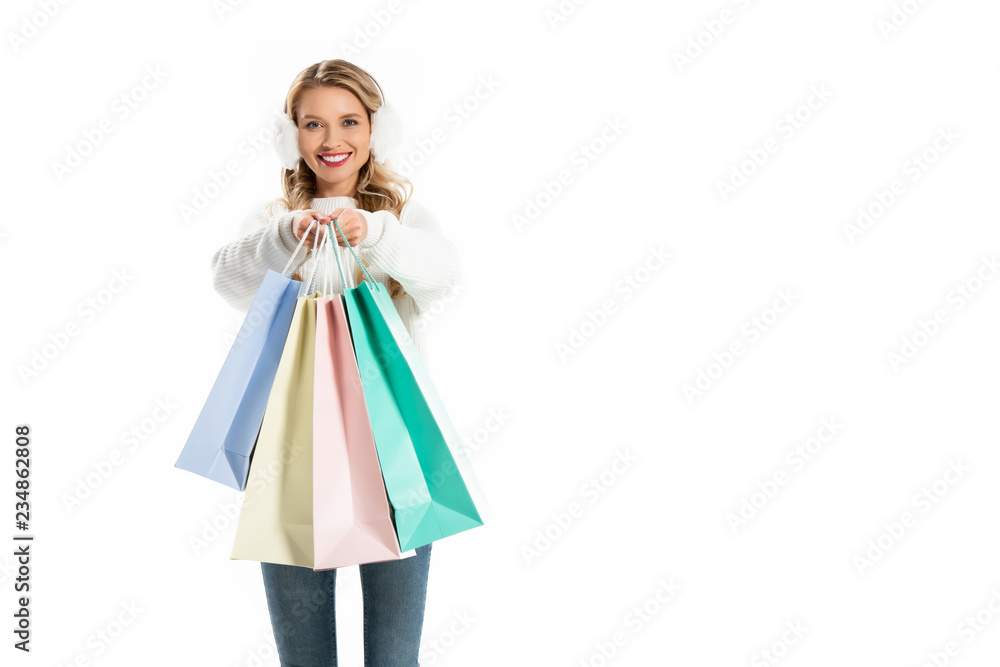 attractive woman in winter outfit holding shopping bags isolated on white