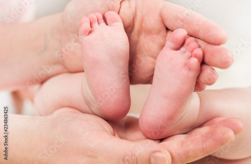 Parent holds gentle little feet in a newborn baby ©  Даниил Дудник