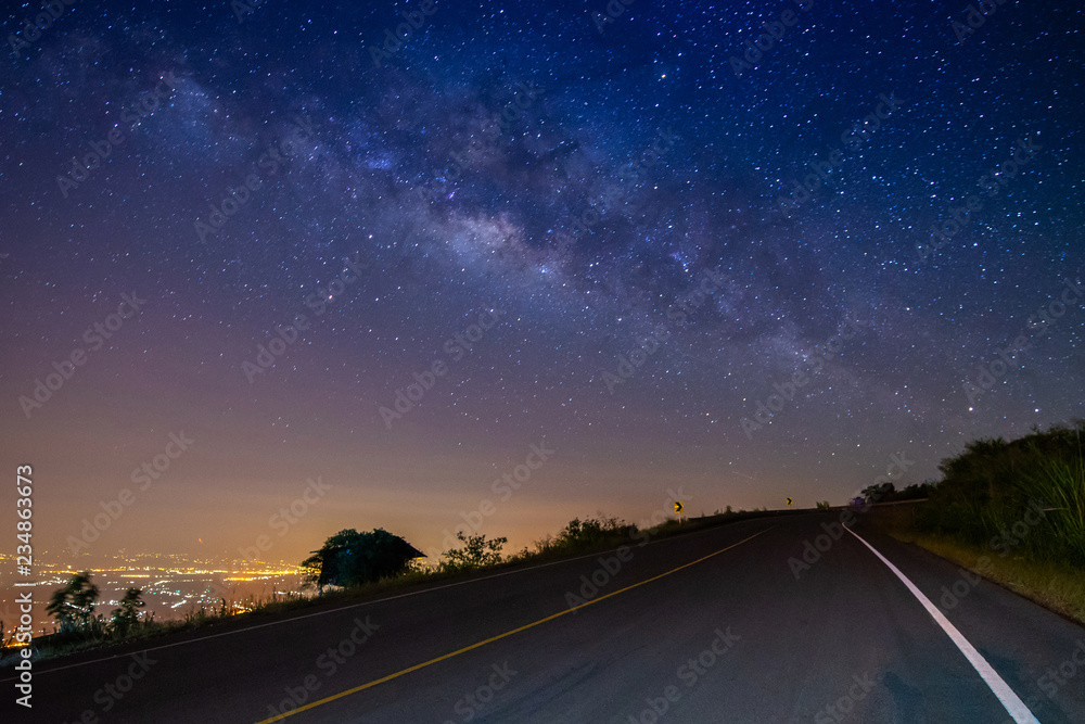 Naklejka premium night landscape road on mountain and milky way galaxy background ,Thailand , long exposure , low light