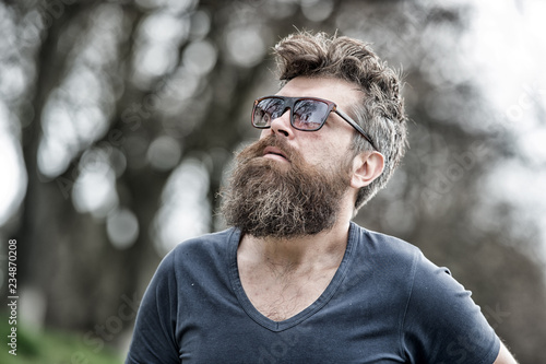 Man bearded with mustache serious face confident nature background. Bearded man with sunglasses. Hipster bearded confident in dark fashionable sunglasses. Bearded hipster brutal macho. Barber concept