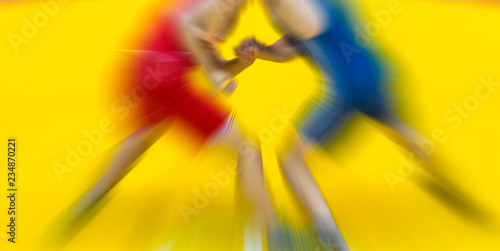 Two wrestling fighting on yellow background. Zoom blur. photo