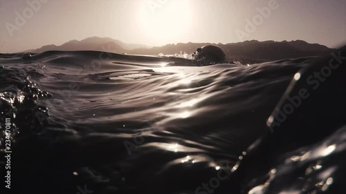 Athletic young man swimming at sea. Professional triathlon swimmer in action
